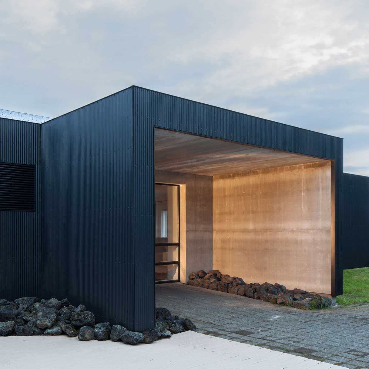 Minimalist black-clad architectural entrance with warm integrated accent lighting